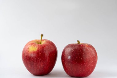 Beyaz arka plana karşı iki kırmızı elma. Kraliyet gala elmaları. Yiyecek ürünleri fotoğrafçılığı