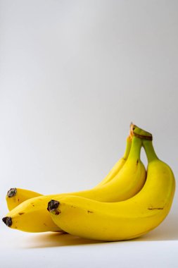 Beyaz arka planda üç olgun sarı muz. Sağlıklı yiyecekler, yiyecek ürünleri fotoğrafçılığı