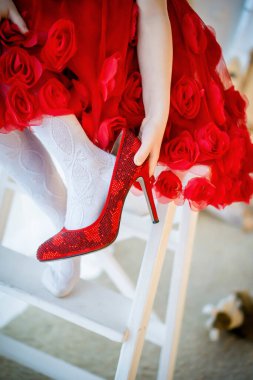 Kız annesinin ayakkabılarını, kırmızı elbisesini ve yüksek topuklu ayakkabılarını alır.