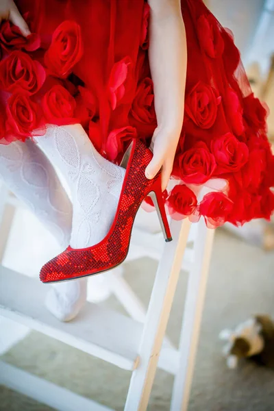 Kız annesinin ayakkabılarını, kırmızı elbisesini ve yüksek topuklu ayakkabılarını alır.