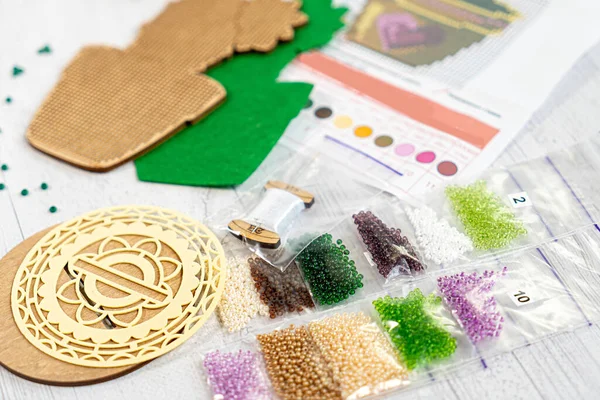 Boncuklanmaya hazır. Paketlerdeki boncuklar. Palette nakış işliyor.
