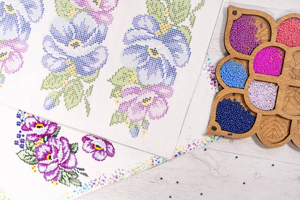 Boncuklanmaya hazır. Paketlerdeki boncuklar. Palette nakış işliyor.