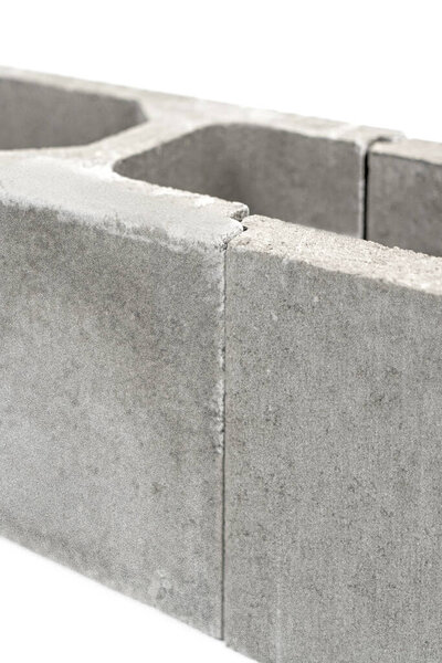 бетонная опалубка для строительства фундамента. Архитектурные крепежи укрепляют цементный забор на белом фоне