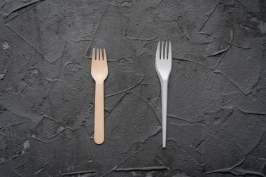 Siyah arka planda tahta bıçak ve çatal var. Çevre dostu sıfır atık kavramı. Metin kopyalama alanı için en üstteki görünüm