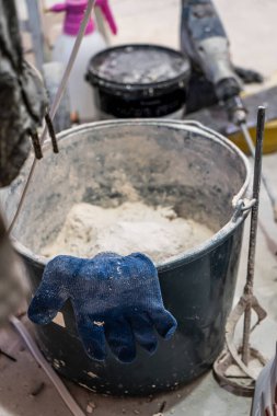 Duvar sıvama aletleriyle ev yenileme yapan bir el işçisi. Kapalı duvarları ve tavanları alçı ve şamandıra ile yenileyen sıva. Odaya el yapımı spatulayla duvar ören mutlu işçi.