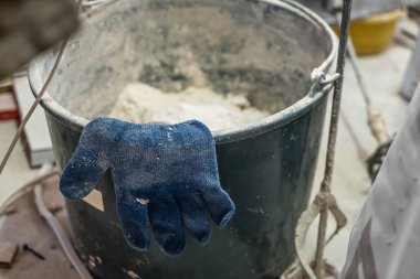 Duvar sıvama aletleriyle ev yenileme yapan bir el işçisi. Kapalı duvarları ve tavanları alçı ve şamandıra ile yenileyen sıva. Odaya el yapımı spatulayla duvar ören mutlu işçi.