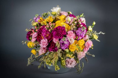 Gri arka planda izole edilmiş bir buket çiçeği kapat. Pastel renkte narin bir buket. Yaz çiçekleri.