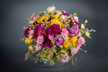 Gri arka planda izole edilmiş bir buket çiçeği kapat. Pastel renkte narin bir buket. Yaz çiçekleri.