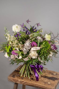 Küçük pembe çiçekleri yakın plan cam vazoda, gri arka planda. Düğün ya da doğum günü, Sevgililer Günü konsepti.