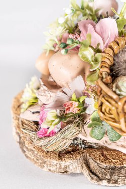 Paskalya masa kompozisyonu tavşanlar ve Paskalya yumurtaları, beyaz arka planda nergis sarısı çiçekler beyaz örülmüş kaplarda. Çiçekli Paskalya tavşanı