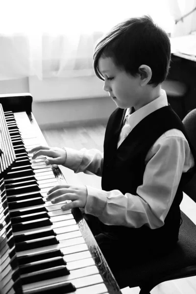 孩子弹钢琴的肖像 年轻男孩在音乐学院用钢琴学习音乐 孩子们弹钢琴放松 — 图库照片