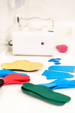 Ortopedik taban. Ortopedist hastayla çalışıyor. Ortopedi kliniği. Ortopedi kliniğinde taban seçimi. Ortopedist hastaya tabanı sunar.