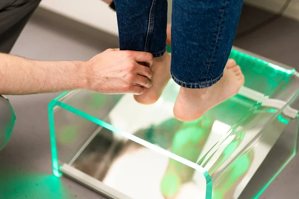 Ortopedik taban. Ortopedist hastayla çalışıyor. Ortopedi kliniği. Ortopedi kliniğinde taban seçimi. Ortopedist hastaya tabanı sunar.