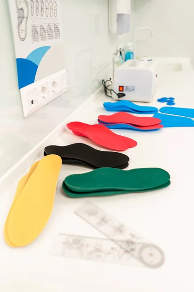 Orthopedic insole. The orthopedist works with the patient. Orthopedic clinic. Choice of insoles in an orthopedic clinic. The orthopedist offers the insole to the patient