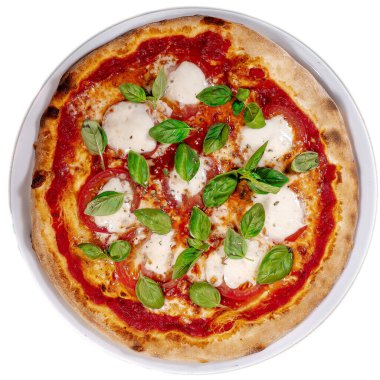 Domatesli Caprese pizzası, mozzarella ve açık gri masada fesleğen.