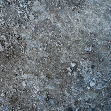 Yerdeki gri-siyah lav dokusuna yakın plan. Gözenekli, çatlak ve taşlı, doku ya da fotoğraf arkaplan olarak mükemmel. Erimiş kayanın etkisi.