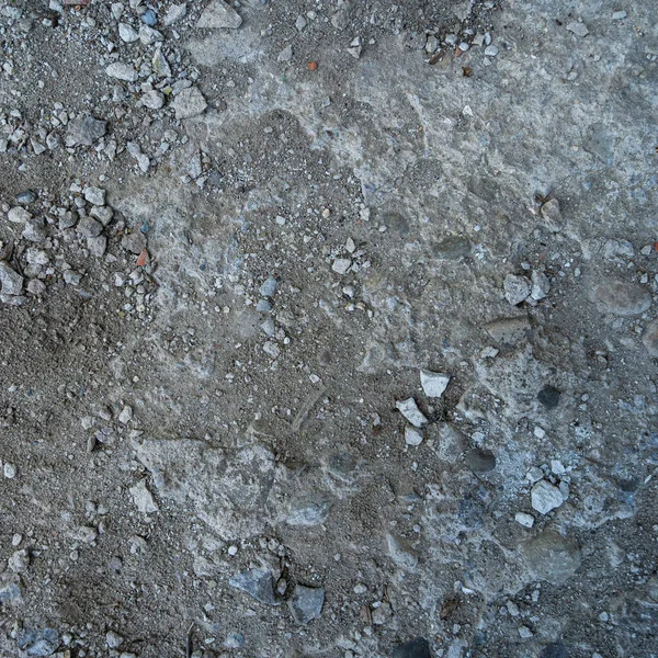 Yerdeki gri-siyah lav dokusuna yakın plan. Gözenekli, çatlak ve taşlı, doku ya da fotoğraf arkaplan olarak mükemmel. Erimiş kayanın etkisi.