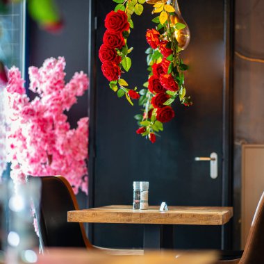 Konforlu ve modern kafe içi ahşap mobilyalar, sıcak ışıklandırma ve sokağa bakan büyük pencerelerle, davetkar bir atmosfer yaratıyor.