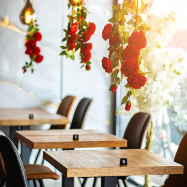 Modern ve zarif bir yemek alanı sunan güzel tasarlanmış bir restoran iç mekanı. Uzay, ahşap sandalyeler ve cam kaplamalı masalar da dahil olmak üzere çağdaş mobilyalara sahip..