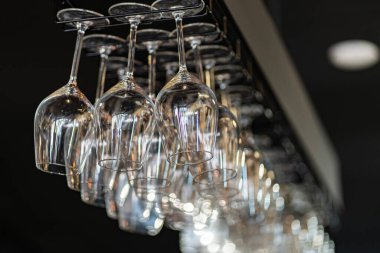 Bar masasında ters çevrilmiş kristal şarap kadehleri.
