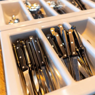 Bir kafede temiz kaşıklar, çatallar ve bıçaklar. Restorandaki çatal bıçak takımı..