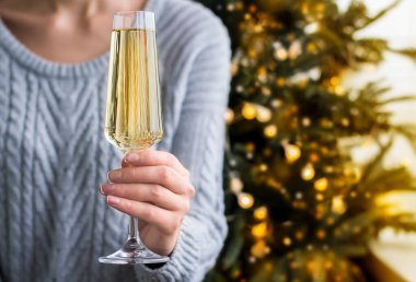 Elinde bir kadeh şampanya tutan genç bir kadın.