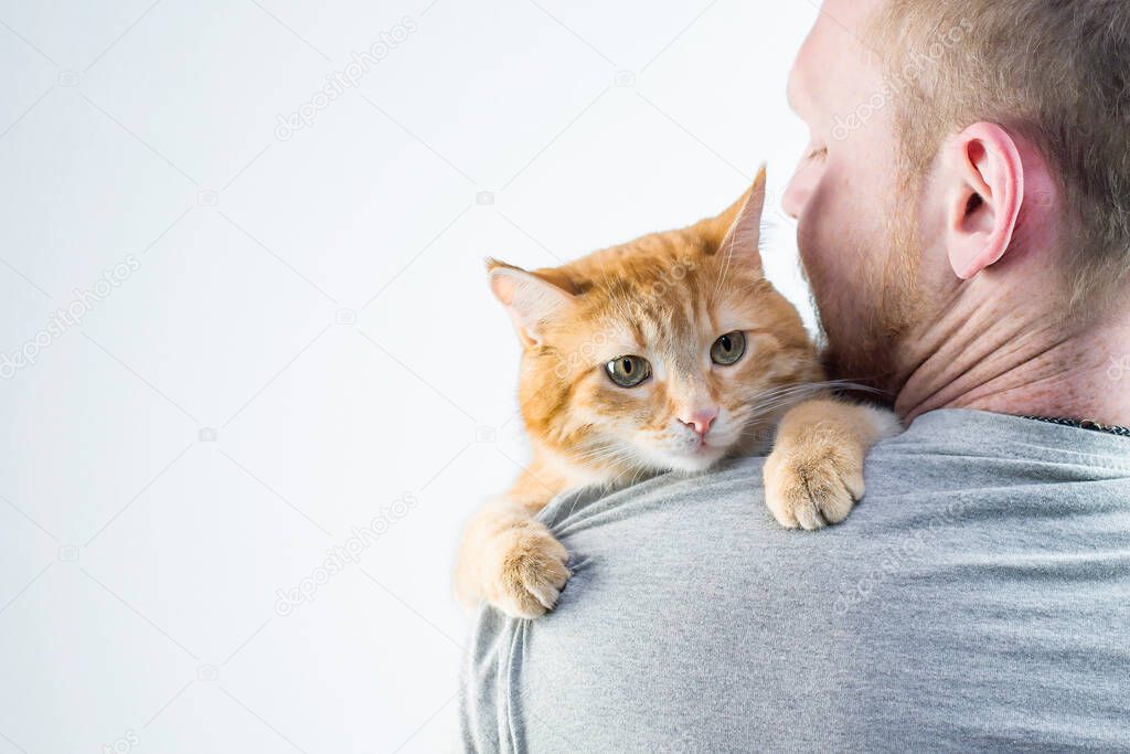 a man with a ginger cat in his arms