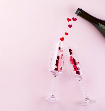 Kırmızı kalpli ve şişeli iki şarap bardağı. Sevgililer Günü konsepti