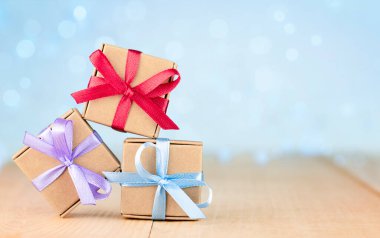 Tahta bir masada üç küçük hediye kutusu. tebrik kartı