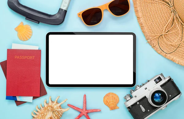 digital tablet and summer accessories around on light blue background