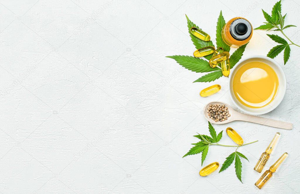 cbd oil, capsules, leaves and seeds  cannabis on gray concrete table, concept of alternative medicine and cannabidiol products