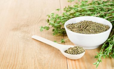 Tahta bir masada taze ve kuru kekik.