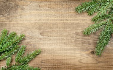 Ahşap masanın üzerinde köknar dalları olan Noel arkaplanı