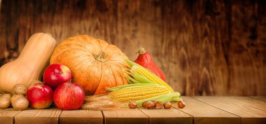 kabaklar, mısır, fındık, buğday ve elmalar ahşap bir masada, hasat ve şükran günü konsepti