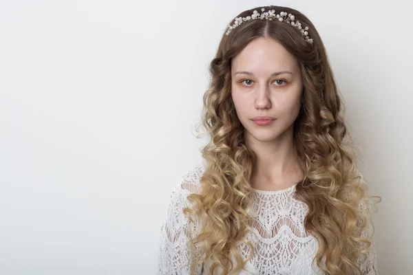 Joven hermosa joven con el pelo largo y rizado, sin maquillaje con una cara limpia con una corona en su cabeza retrato en el estudio sobre un fondo blanco — Foto de Stock