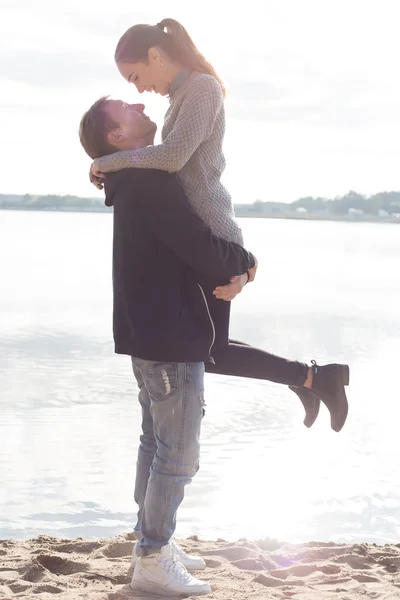 Beautiful young couple walking along the beach on a sunny spring day autumn — Stock Photo, Image