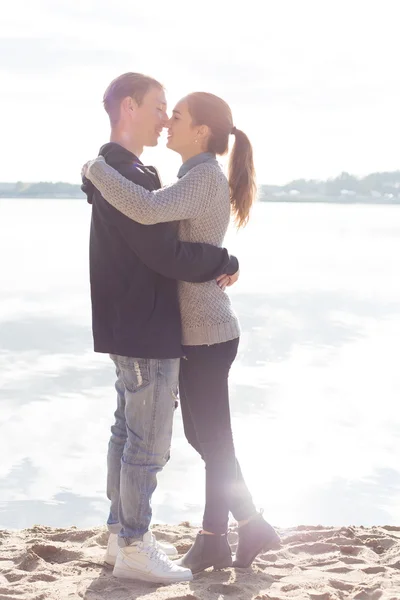 Hermosa pareja joven caminando a lo largo de la playa en un soleado día de primavera otoño — Foto de Stock