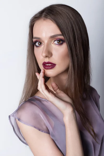 Porträtt av en vacker tjej med en söt fina vinröda läppar och ljusa makeup i en ljus genomskinlig negligé studio på vit bakgrund — Stockfoto
