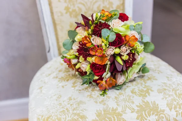 Beautiful bouquet of colorful flowers and green roses lying on a chair close-up — Stock Photo, Image