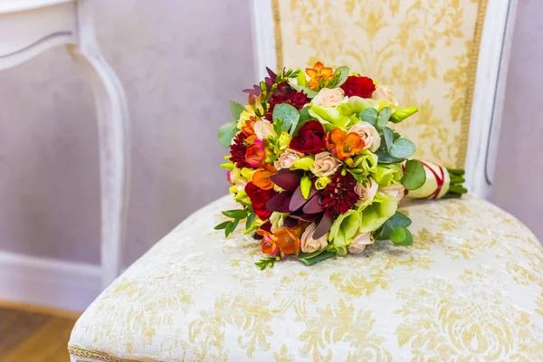 Beautiful bouquet of colorful flowers and green roses lying on a chair close-up — Stock Photo, Image