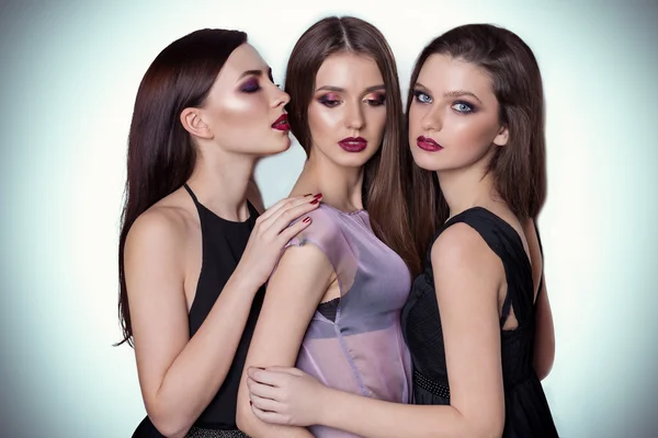 Portret trzech znajomych pięknych młodych kobiet w studio na białym tle z yarkis makijaż są blisko siebie — Zdjęcie stockowe