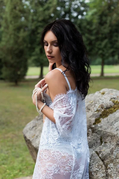 Όμορφη σέξι κορίτσι με σκούρα μακριά μαλλιά σε ένα φόρεμα δαντέλα εσώρουχα και ρόμπα στην φύση καλοκαίρι ζεστό βράδυ — Φωτογραφία Αρχείου