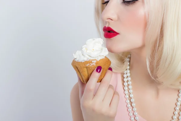 Schöne sexy blonde Mädchen mit roten Lippen essen eine Sahnetorte — Stockfoto