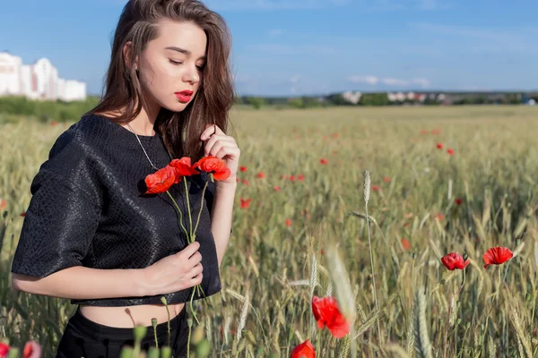 Bella giovane donna sexy carina con labbra piene di capelli corti in un campo con fiori di papavero nelle loro mani — Foto Stock