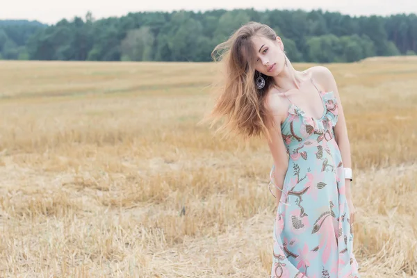 beautiful red-haired sexy girl in bright summer sundress with big lips plump playing field