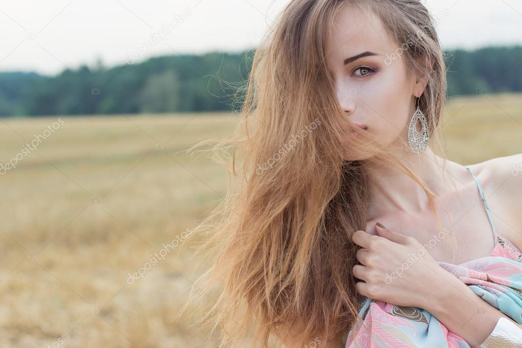 beautiful red-haired sexy girl in bright summer sundress with big lips plump playing field