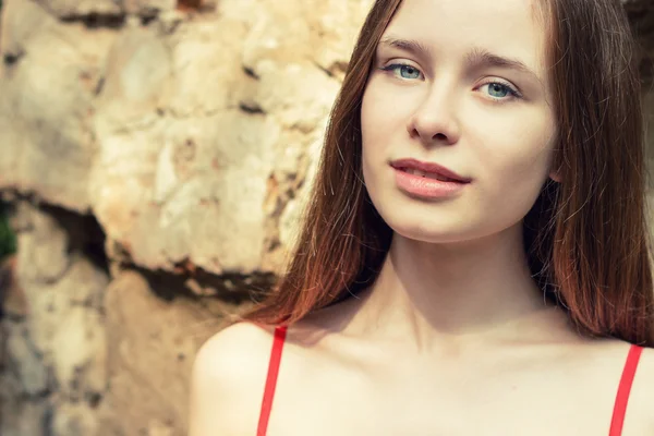 Portrait d'une belle fille aux cheveux roux avec des lèvres dodues dans une robe rouge un jour d'été dans la rue — Photo