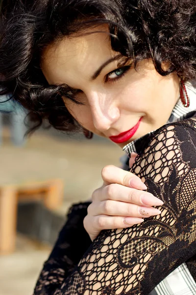 Portrait d'une belle fille sexy avec des lèvres rouges brune avec des boucles promenades dans le parc — Photo