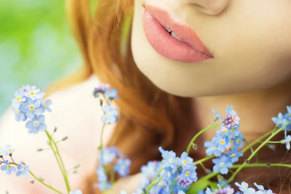 Big sexy lips girls with blue flowers in her hands — Stock Photo, Image