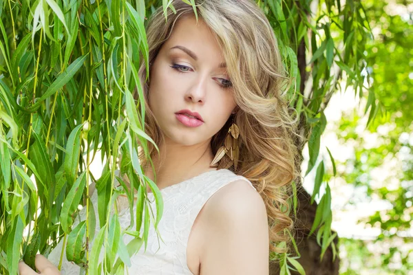Portrait of a beautiful sexy girl with big full lips, with white hair in a white dress near a tree — Stock Photo, Image